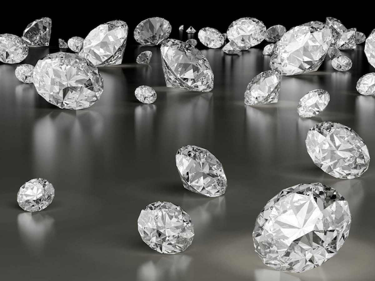 Collection of GIA-certified loose round brilliant diamonds on dark reflective surface
