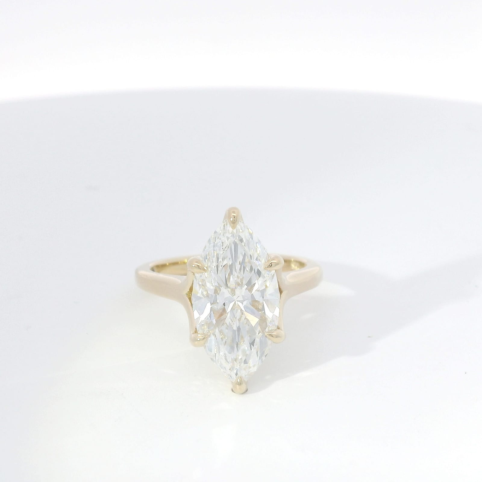 Marquise-cut diamond solitaire in yellow gold with double-claw prongs