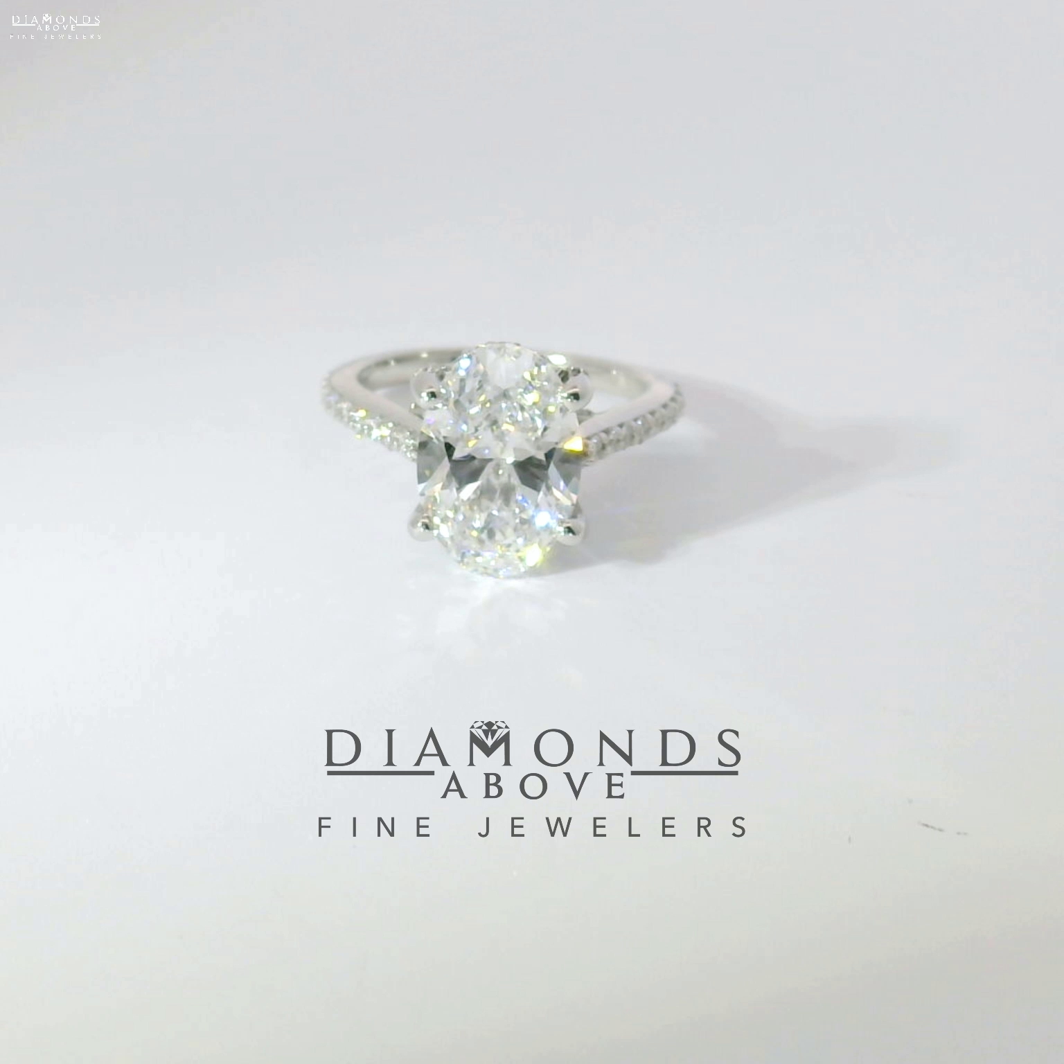 Oval diamond solitaire with pavé diamond band in white gold