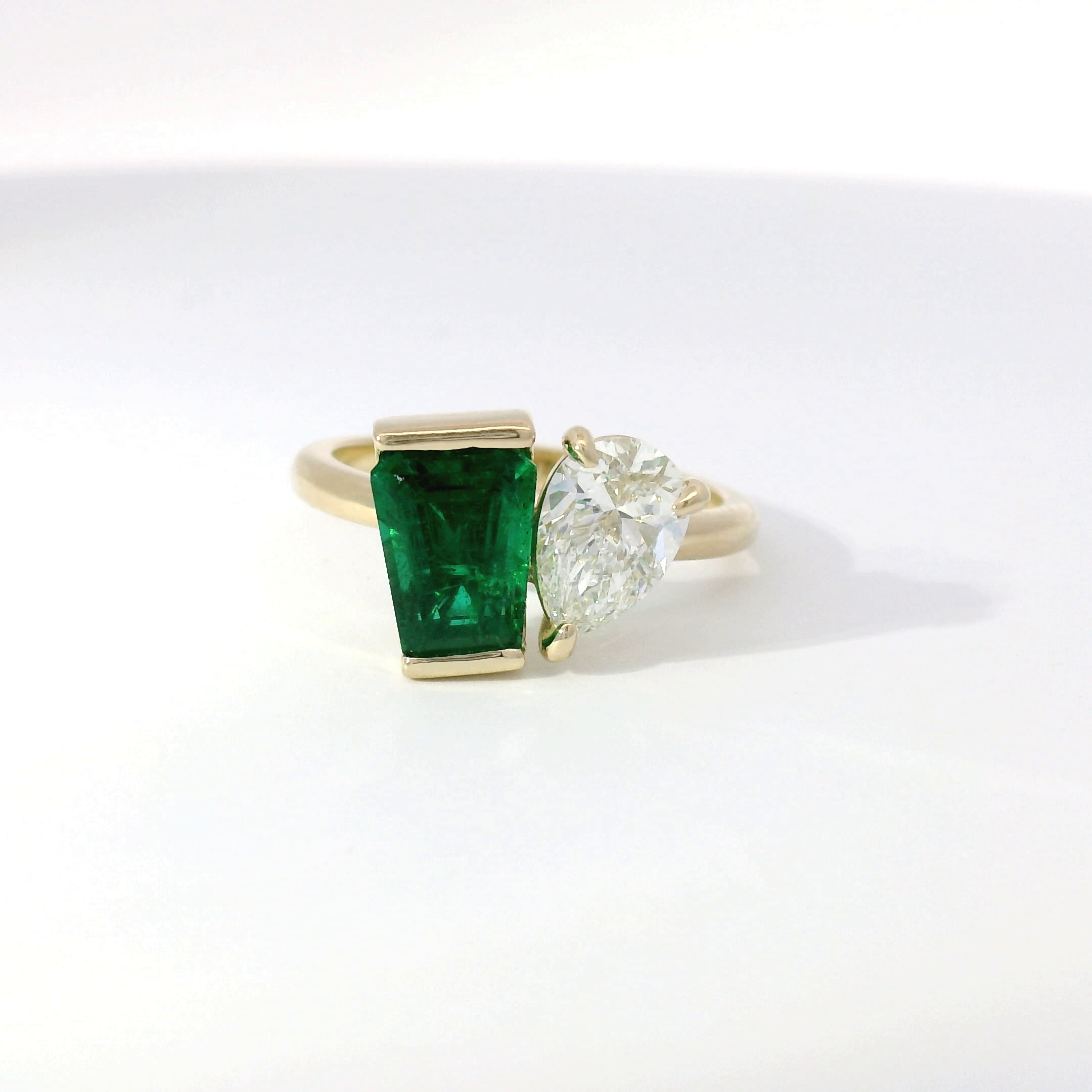 Toi-et-moi ring with green emerald and pear-shape diamond side by side in yellow gold