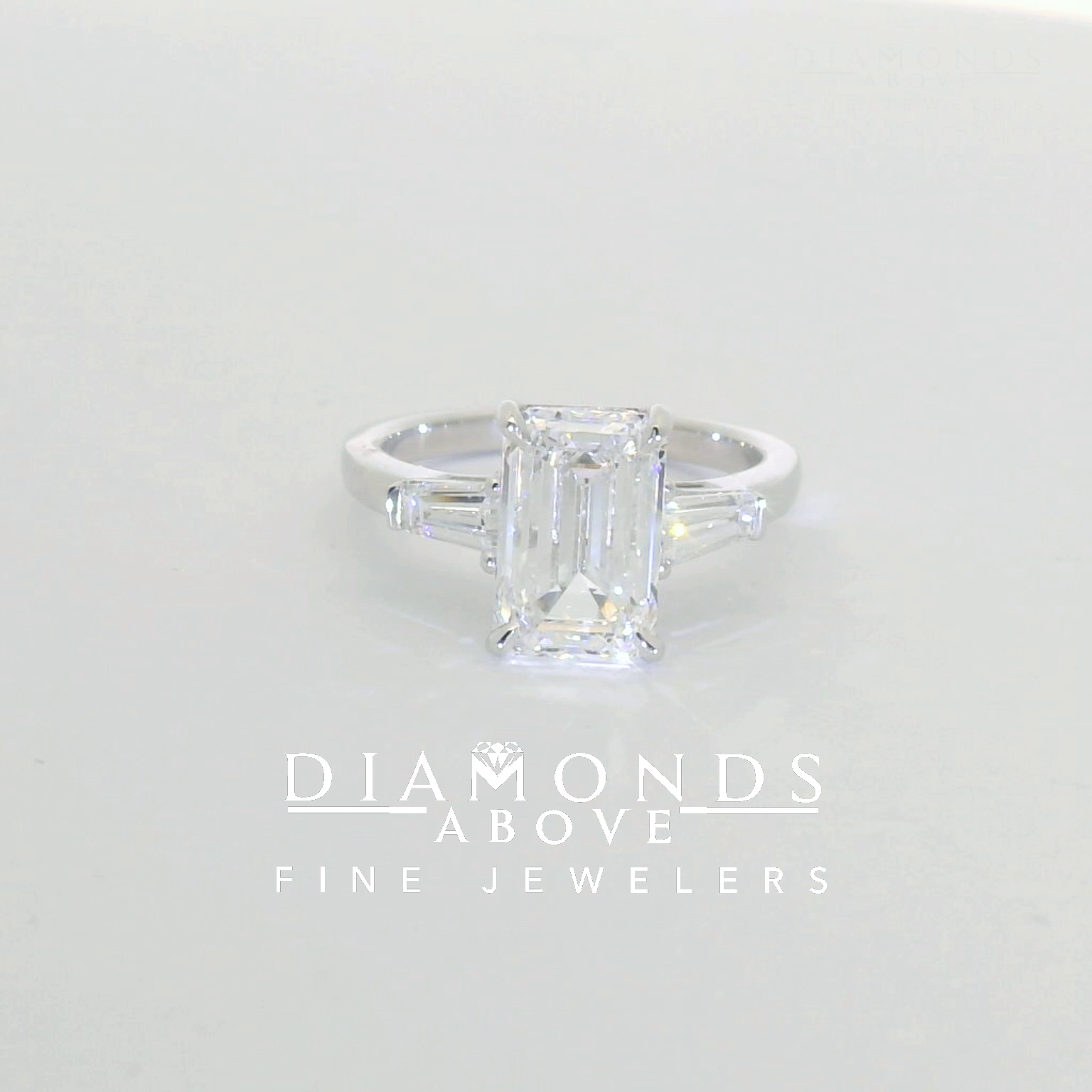 Emerald-cut diamond with tapered baguette side stones in platinum