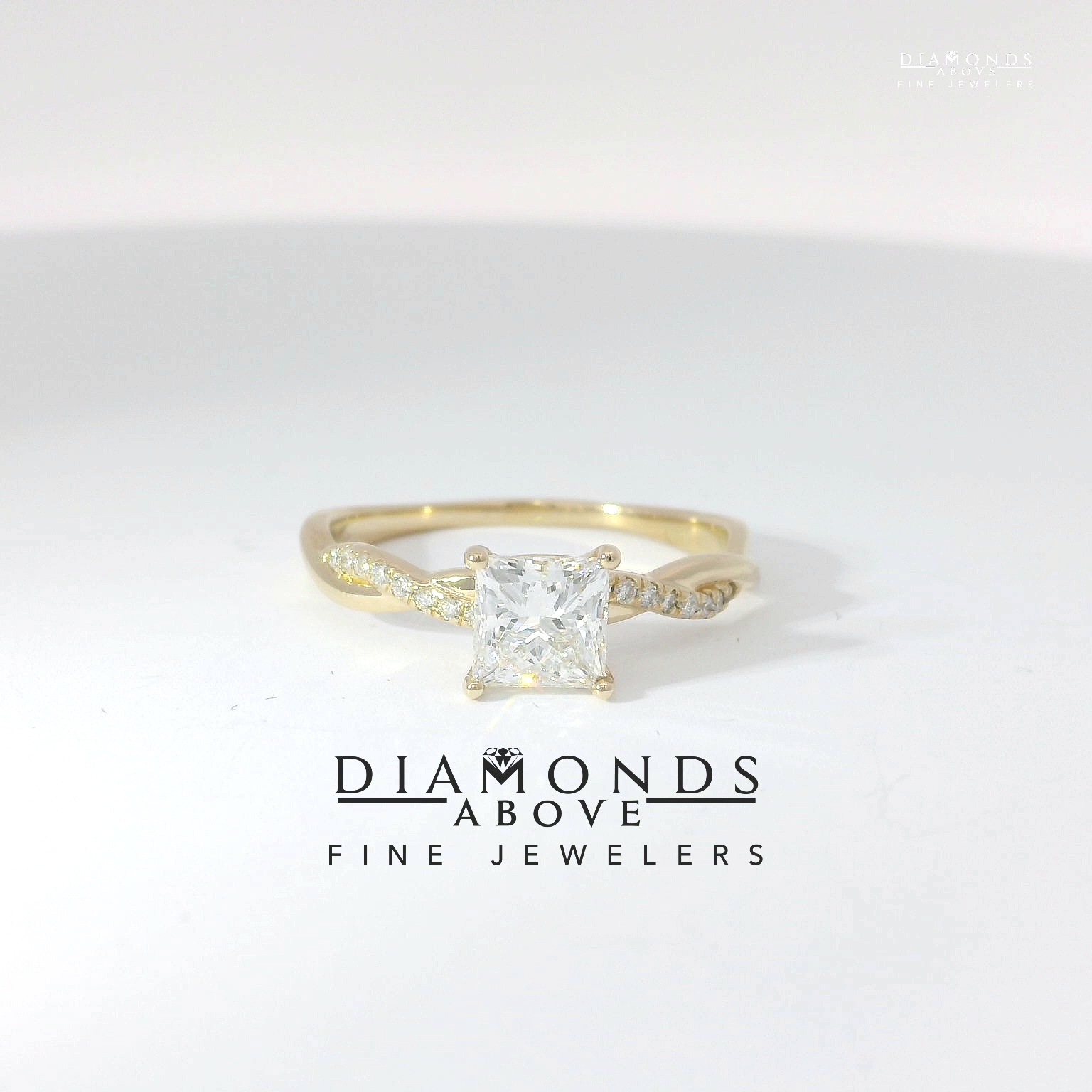 Princess-cut diamond solitaire with twisted pavé infinity shank in yellow gold