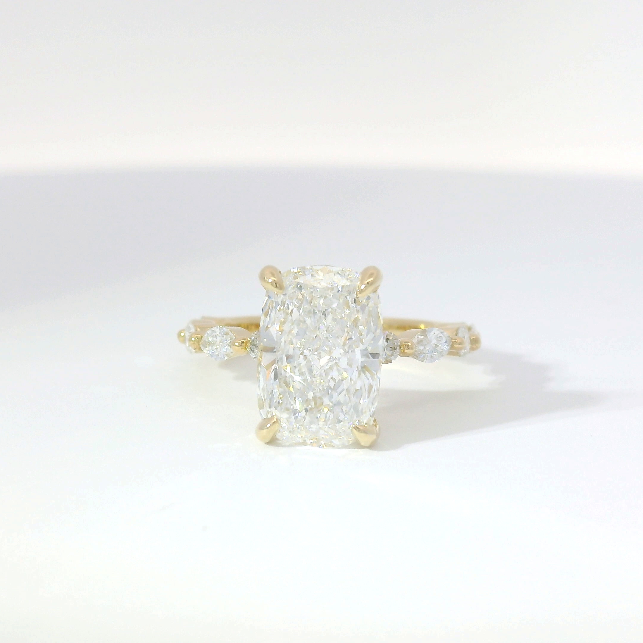 Elongated cushion-cut diamond solitaire with pavé band in two-tone gold