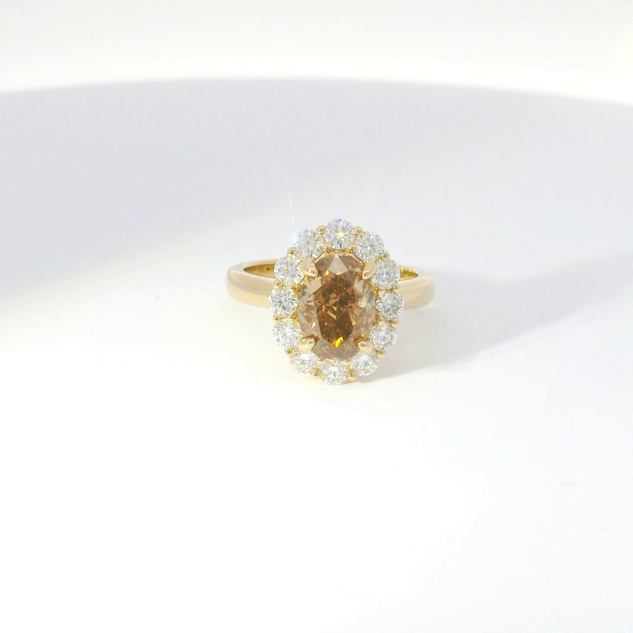 Fancy cognac oval diamond with diamond halo in yellow gold