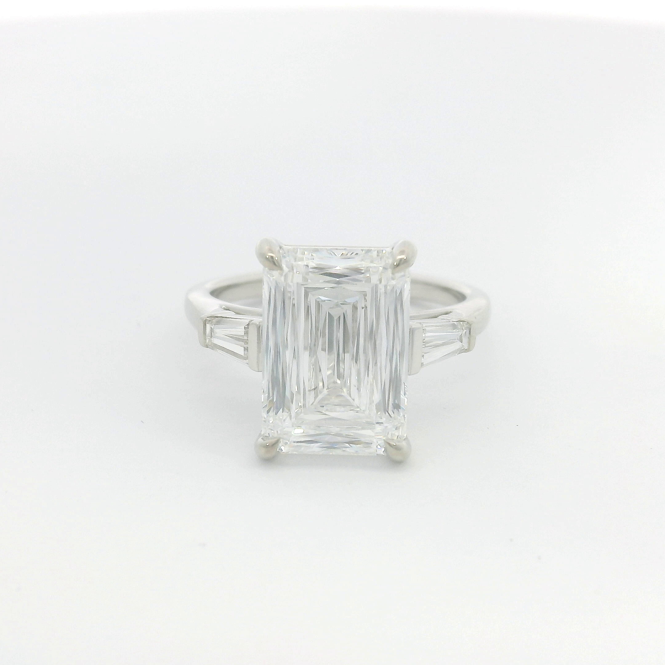 Emerald-cut diamond with tapered baguette side stones in platinum