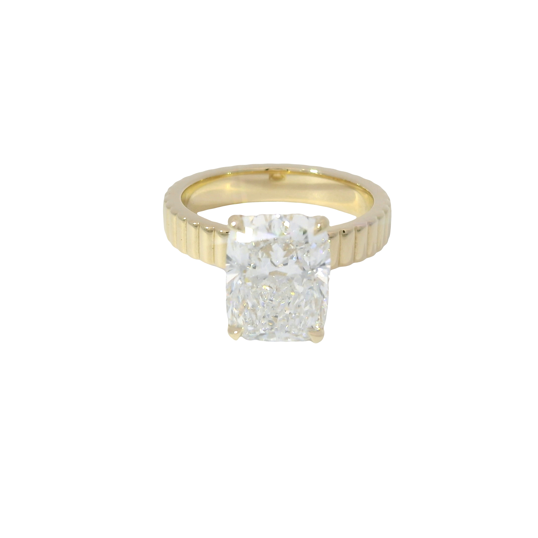 Cushion-cut diamond solitaire on a fluted yellow gold band
