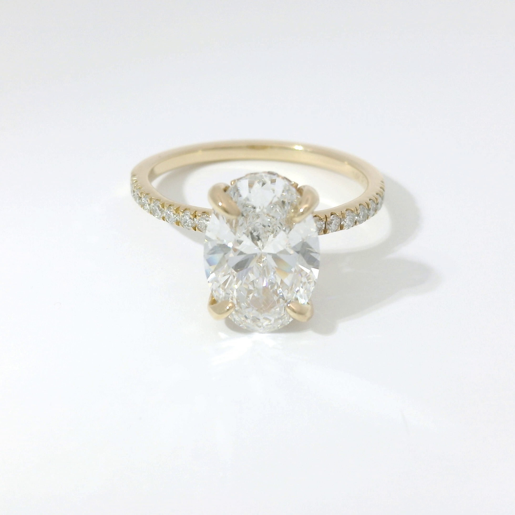 Oval diamond solitaire with pavé band in yellow gold