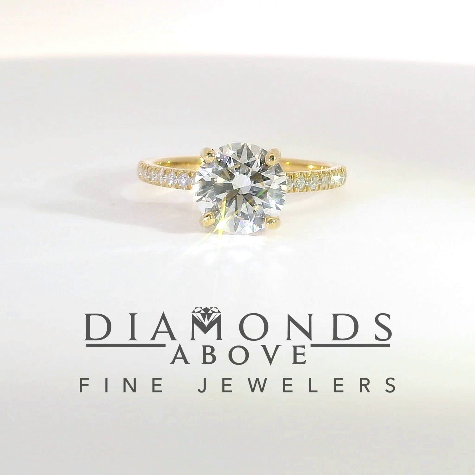 Round brilliant diamond solitaire in yellow gold with diamond pavé band