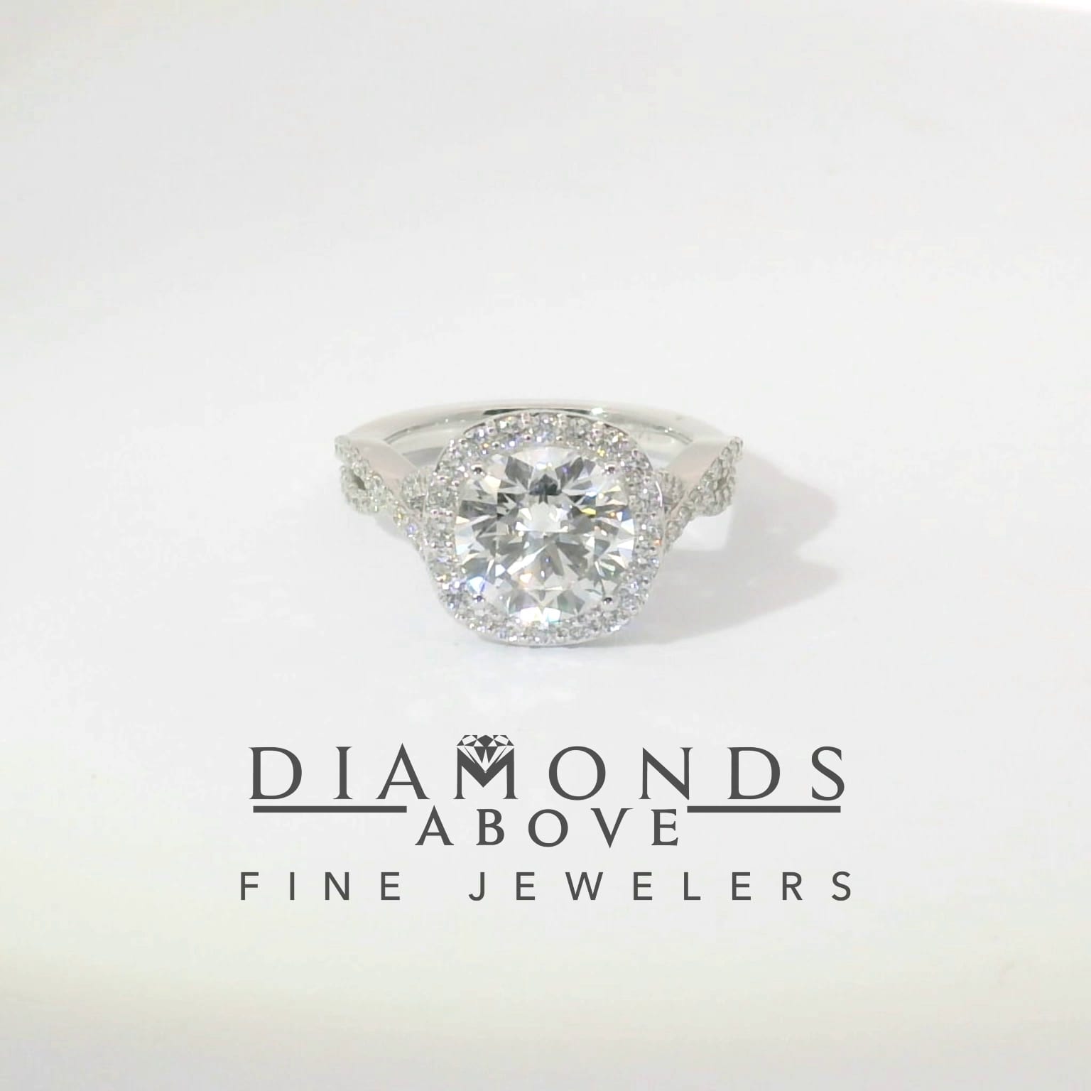 Round brilliant diamond cushion halo on twisted diamond pavé infinity shank