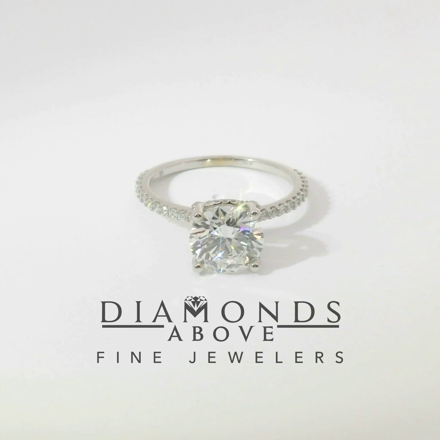 Round brilliant diamond solitaire with white gold diamond pavé band