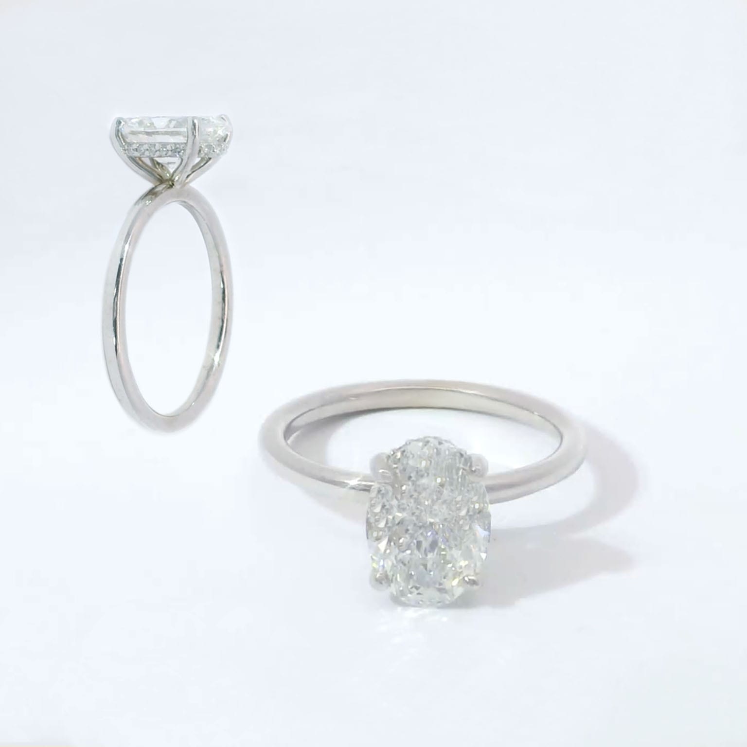 Oval diamond solitaire with hidden halo on a plain polished band in white gold