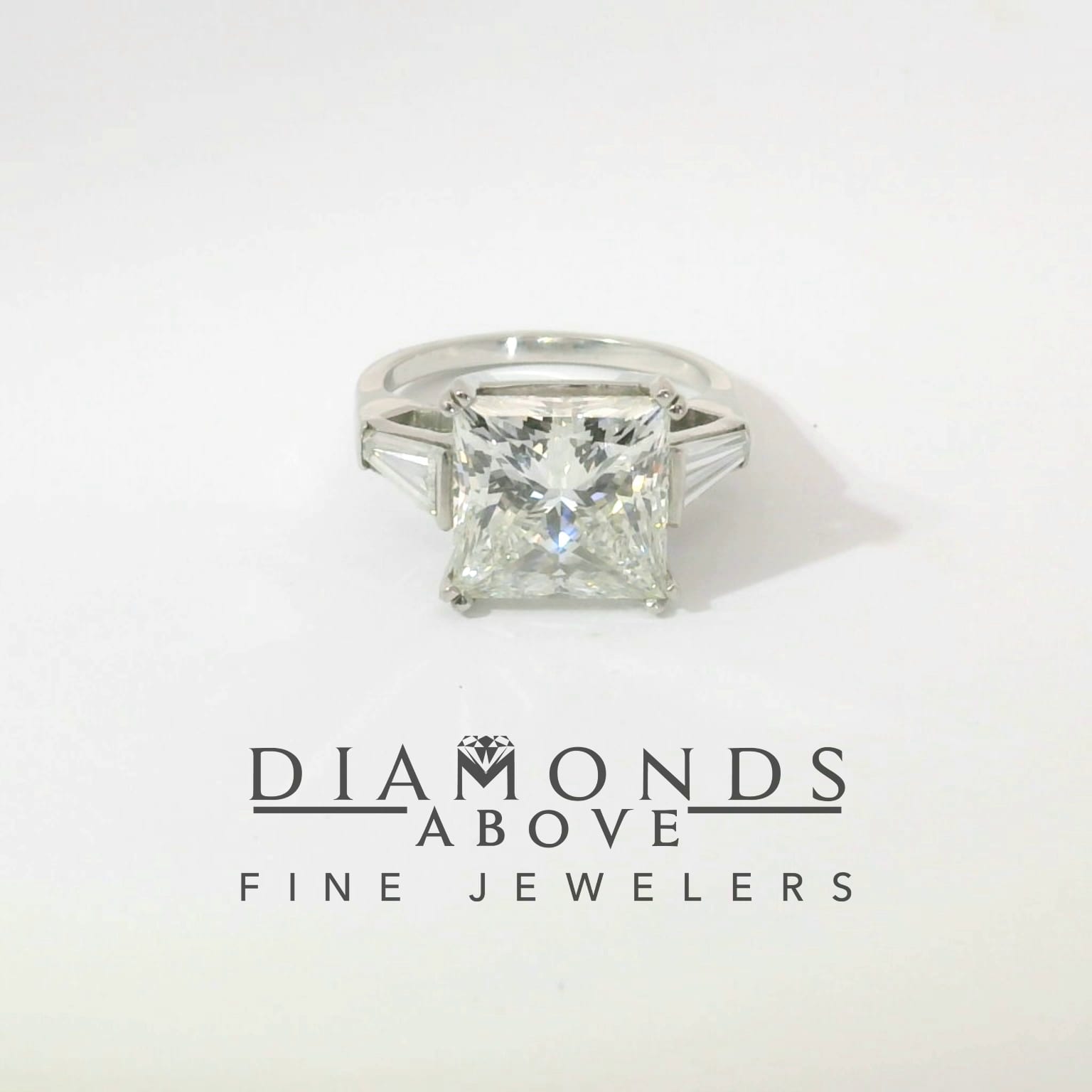 Princess-cut diamond three-stone engagement ring with tapered baguette side stones