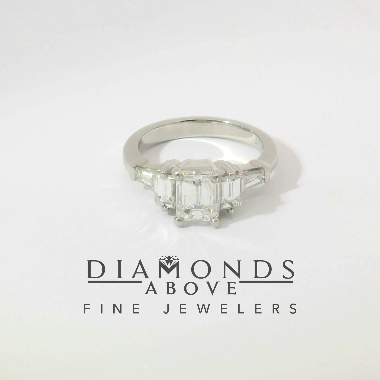 Emerald-cut diamond flanked by step-cut and tapered baguette side stones in platinum