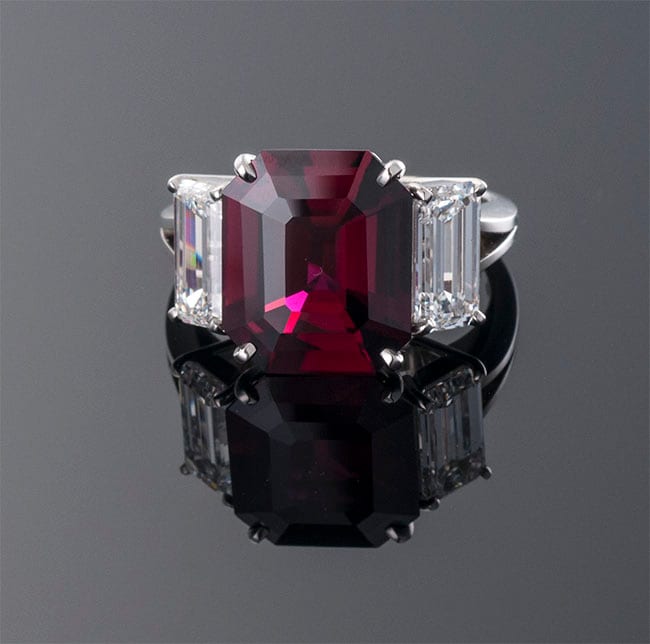 Emerald-cut ruby three-stone ring with trapezoid diamond sides